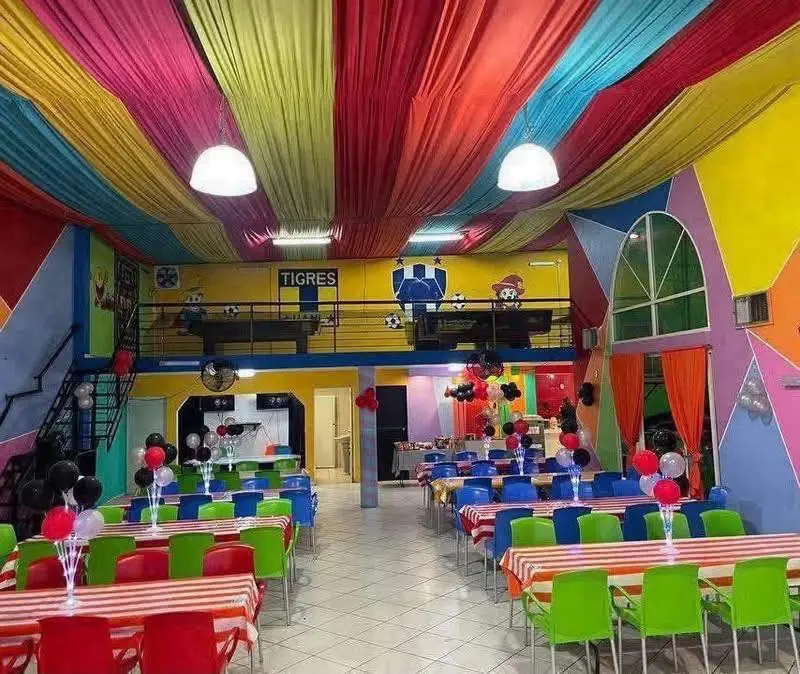 Salón principal con techo drapeado arcoíris y mesas montadas